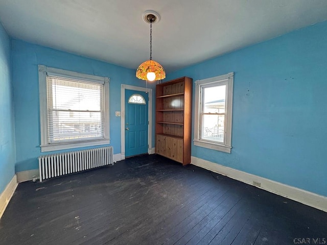 interior space with dark wood finished floors, radiator heating unit, and baseboards