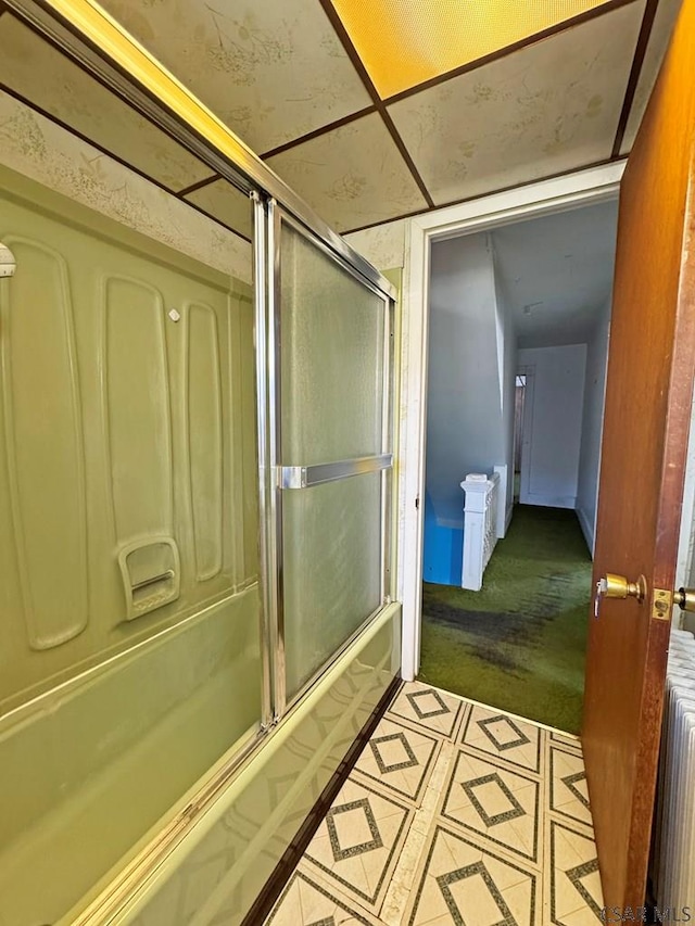 bathroom featuring radiator and combined bath / shower with glass door