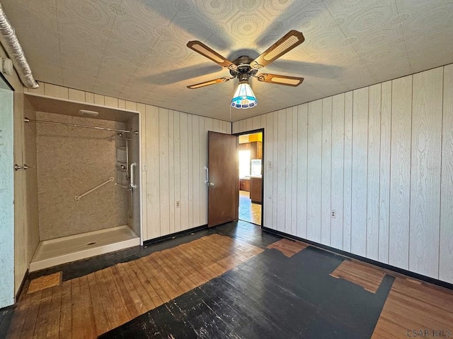 unfurnished room with baseboards, wood-type flooring, and a ceiling fan