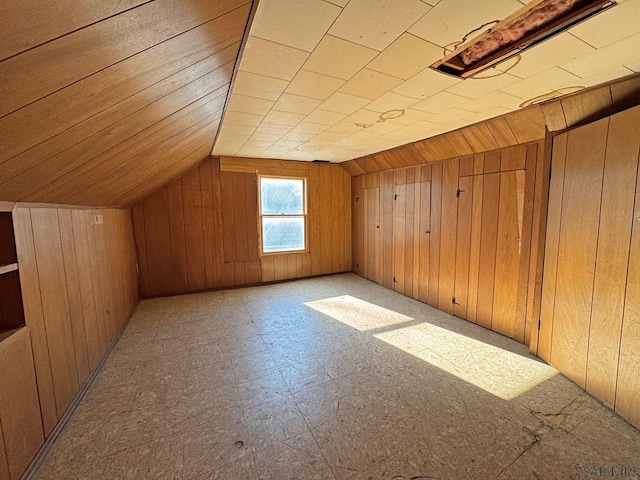 bonus room featuring tile patterned floors, lofted ceiling, and wood walls