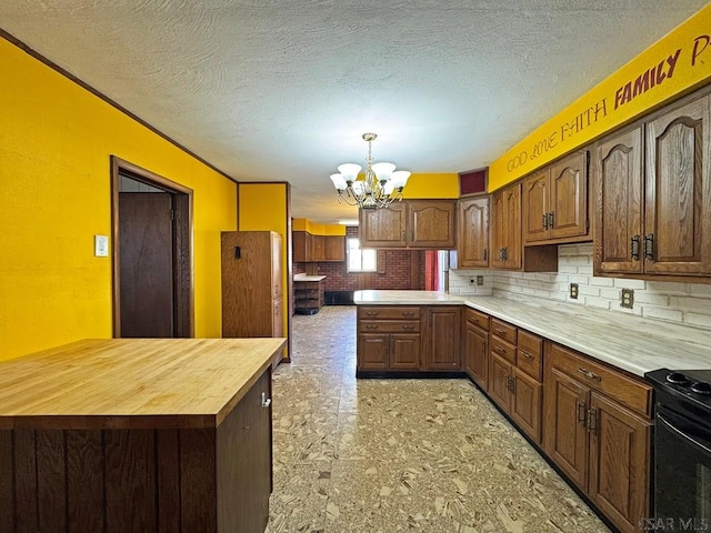 kitchen with backsplash, wooden counters, a notable chandelier, and a textured ceiling