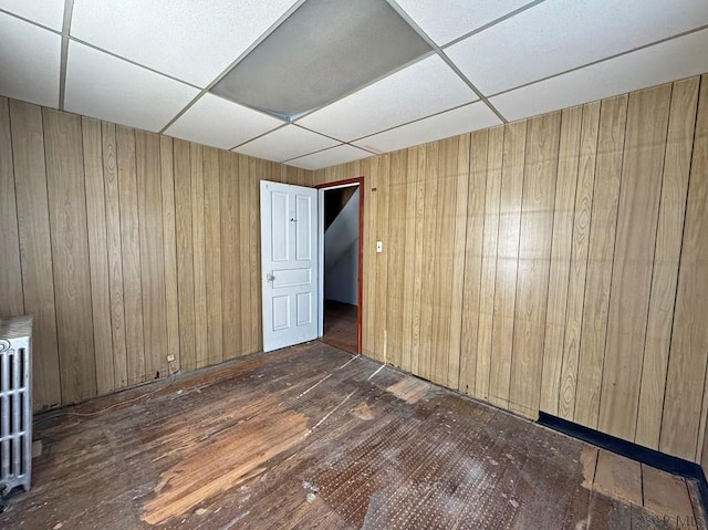 spare room with wood walls and a paneled ceiling