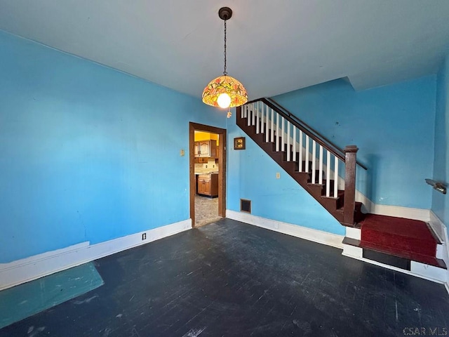 unfurnished living room featuring stairs, baseboards, and visible vents