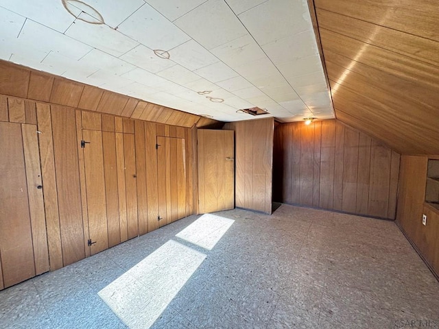 additional living space with lofted ceiling and wooden walls