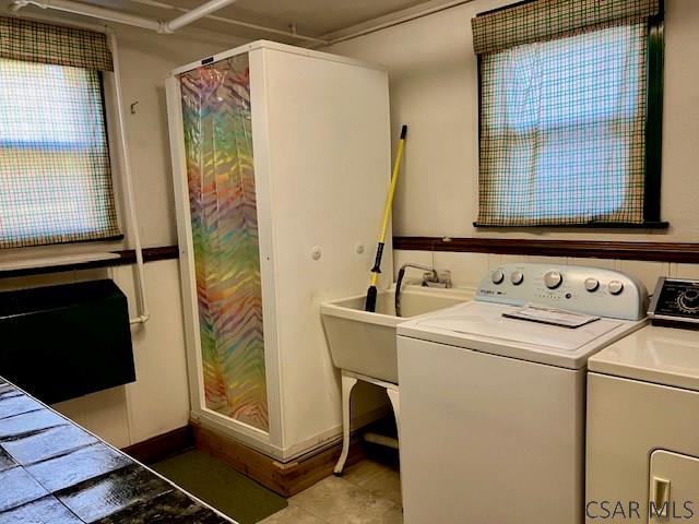 laundry area featuring washing machine and clothes dryer, laundry area, and a sink