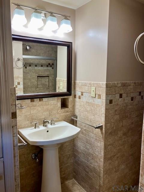 bathroom with a wainscoted wall and tile walls