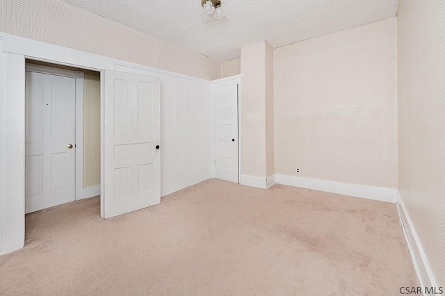 unfurnished bedroom featuring light colored carpet and a textured ceiling