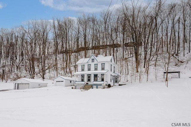 view of front of house with a garage, an outbuilding, and covered porch