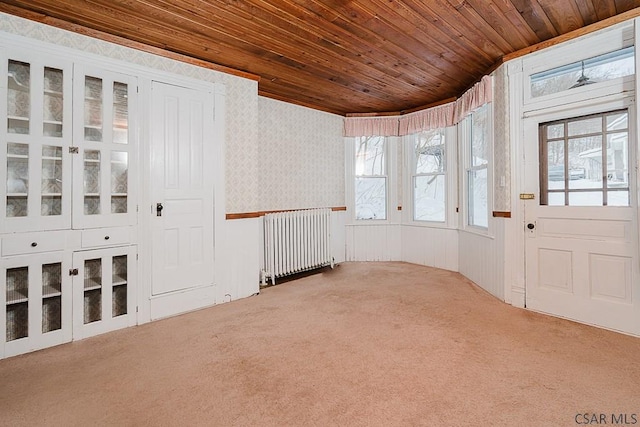 carpeted foyer entrance with wood ceiling and radiator heating unit