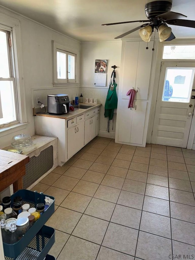 kitchen with white cabinetry, a wealth of natural light, ceiling fan, and light tile patterned flooring