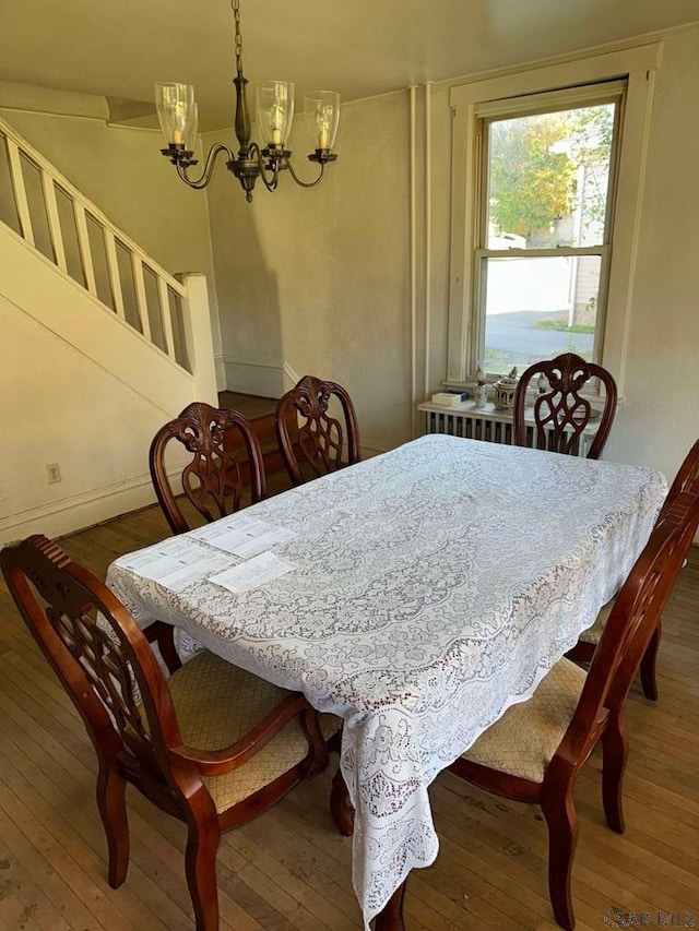 dining area featuring hardwood / wood-style floors and a chandelier