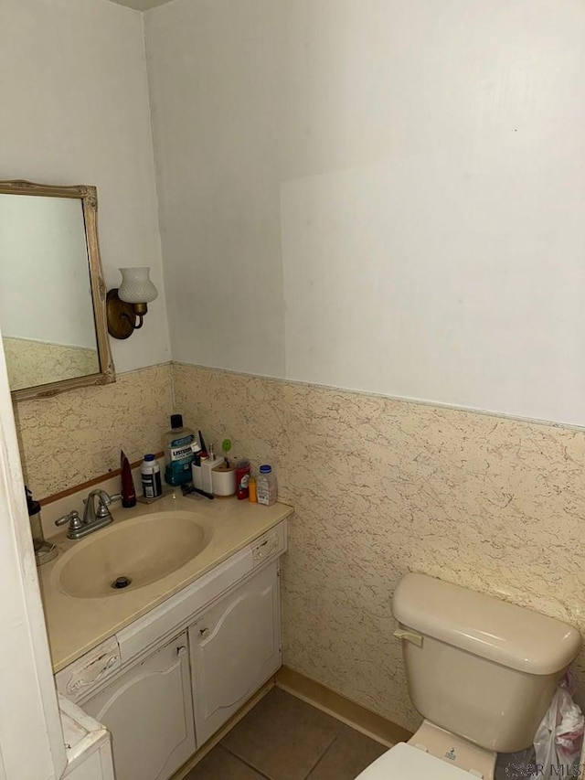 bathroom featuring vanity, tile patterned floors, and toilet