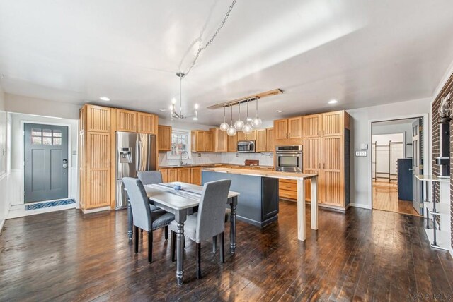 dining area featuring sink, dark wood-type flooring, a chandelier, and plenty of natural light