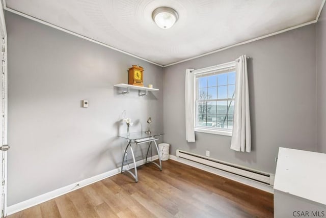 clothes washing area featuring hardwood / wood-style floors and a baseboard radiator