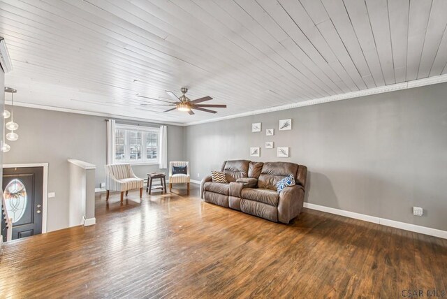 living room with a ceiling fan, crown molding, baseboards, and wood finished floors