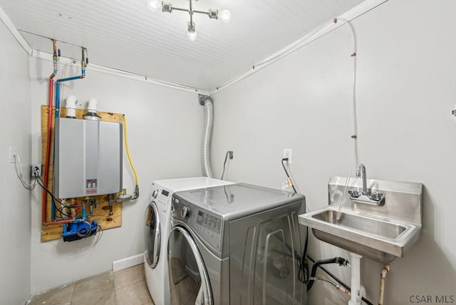 laundry room with tankless water heater, tile patterned flooring, laundry area, a sink, and washing machine and clothes dryer