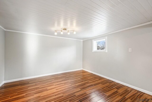 empty room with crown molding and wood-type flooring