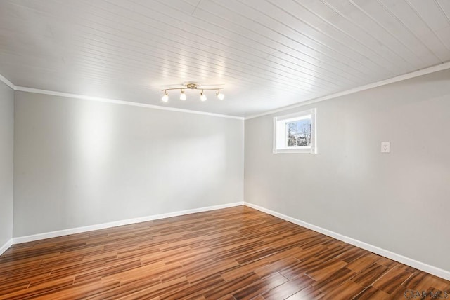 unfurnished room featuring baseboards, wood finished floors, and crown molding