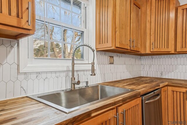 kitchen featuring tasteful backsplash, sink, and wood counters