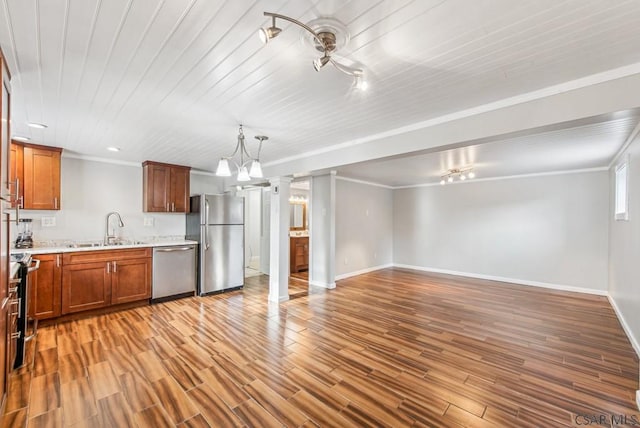 kitchen with sink, stainless steel appliances, ornamental molding, light hardwood / wood-style floors, and decorative light fixtures