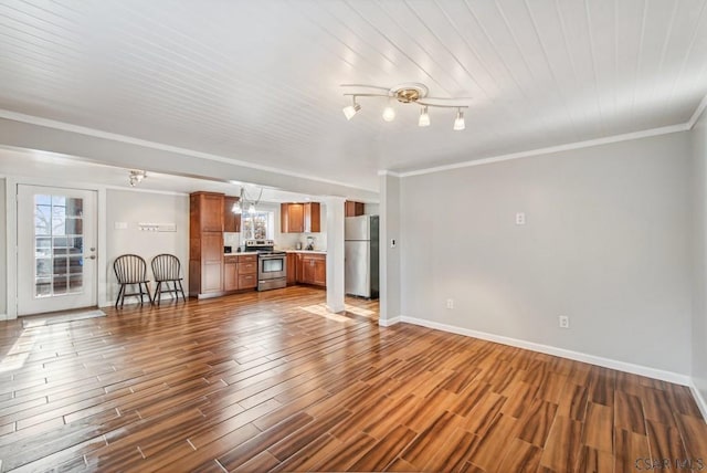 unfurnished living room with an inviting chandelier, baseboards, dark wood finished floors, and crown molding