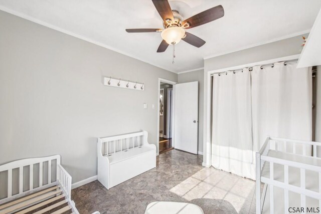 unfurnished bedroom featuring a nursery area and ceiling fan