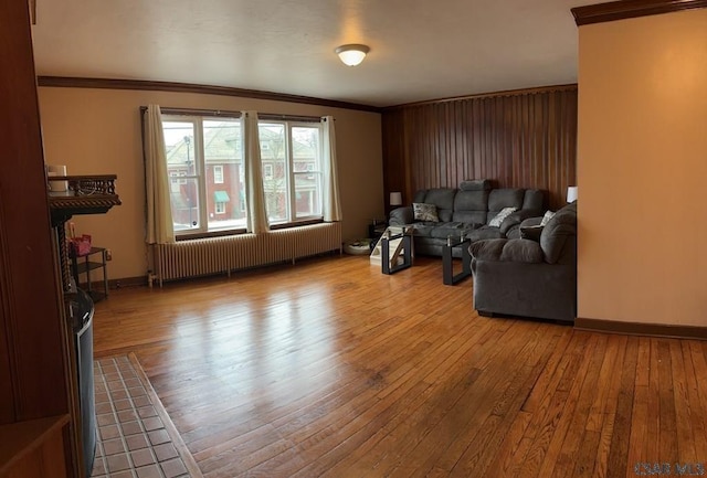 living room featuring radiator, ornamental molding, and light hardwood / wood-style floors