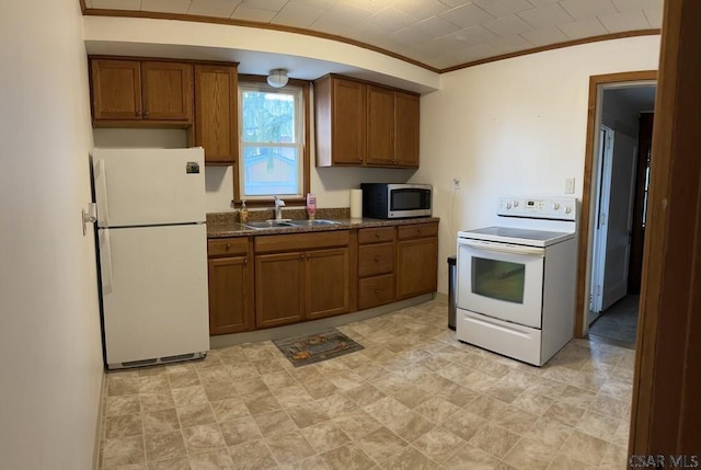 kitchen featuring crown molding, sink, white appliances, and dark stone counters