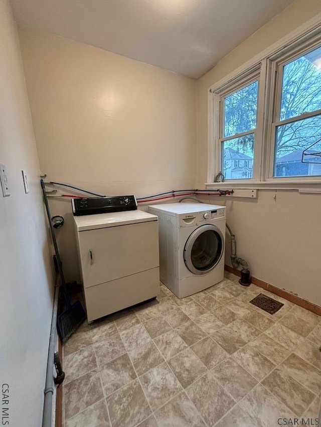 clothes washing area featuring separate washer and dryer