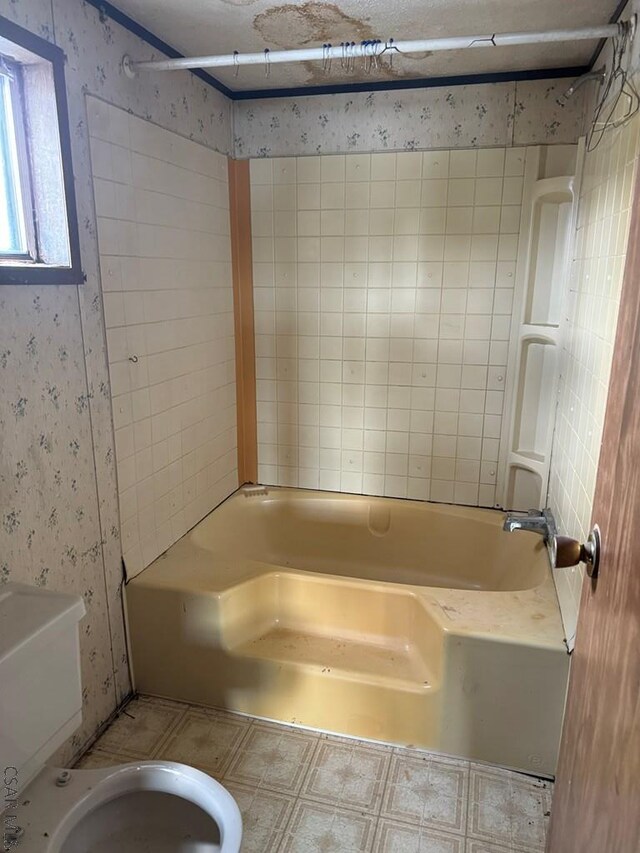 bathroom with bathtub / shower combination and toilet