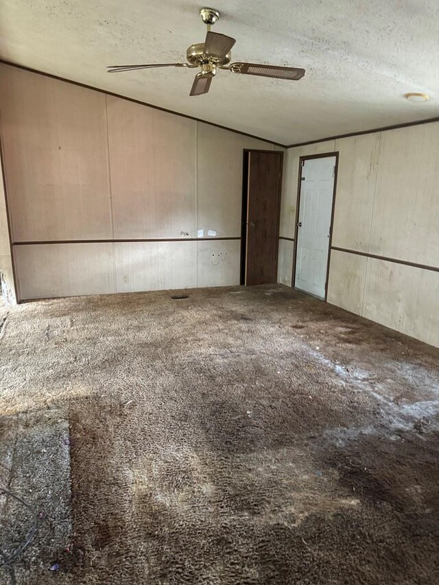 unfurnished room featuring ceiling fan, lofted ceiling, and a textured ceiling