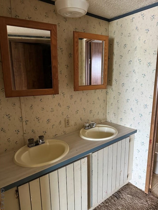 bathroom featuring vanity, ornamental molding, and a textured ceiling