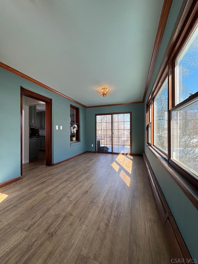 interior space featuring hardwood / wood-style floors, crown molding, and a baseboard radiator