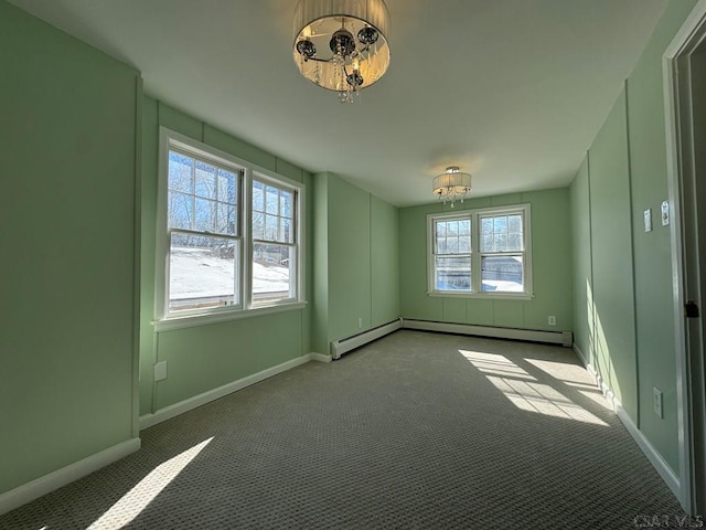 empty room with light carpet, a wealth of natural light, and baseboard heating