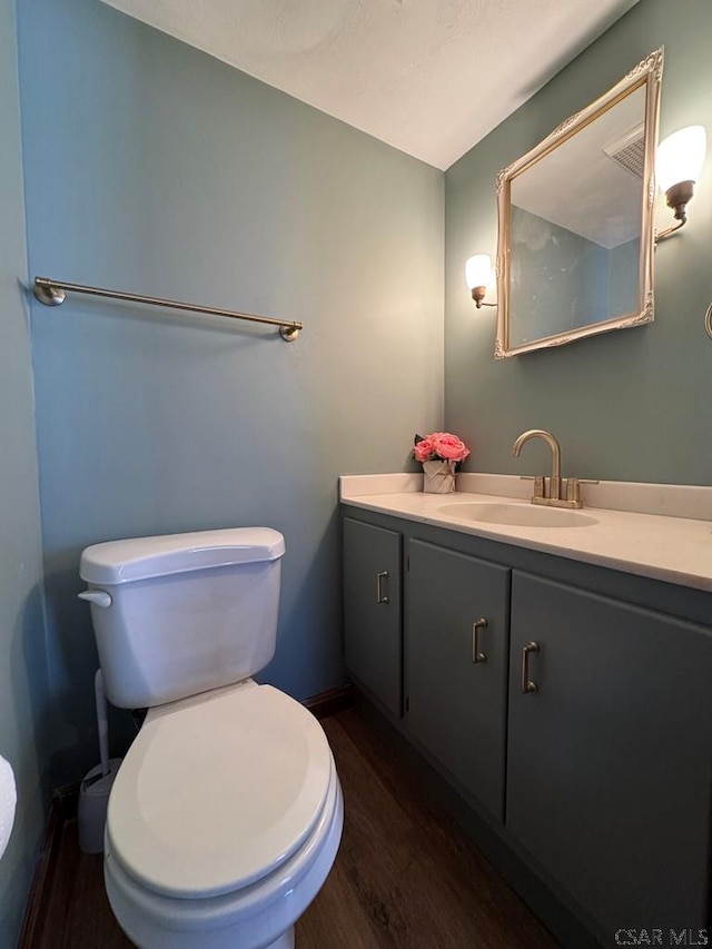 bathroom featuring vanity, hardwood / wood-style floors, and toilet