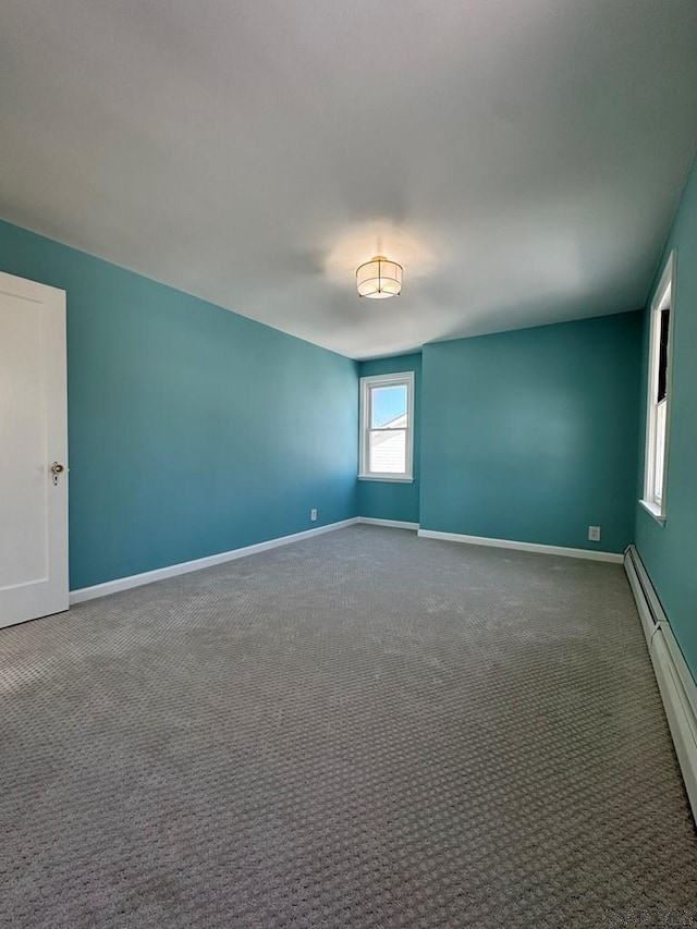 carpeted empty room with baseboard heating