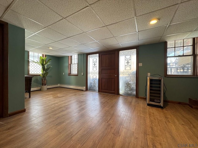 foyer featuring wine cooler, a paneled ceiling, plenty of natural light, and hardwood / wood-style floors