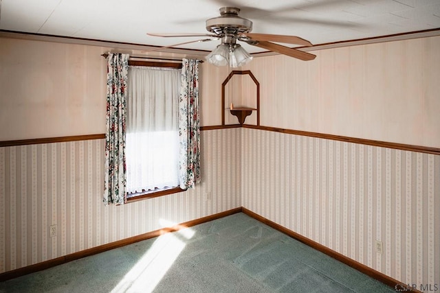 carpeted spare room featuring crown molding and ceiling fan