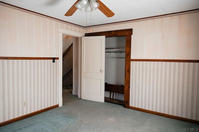 unfurnished bedroom featuring ceiling fan, ornamental molding, light colored carpet, and a closet