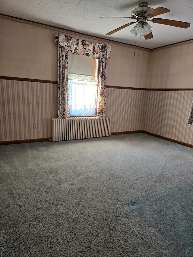 carpeted empty room with radiator heating unit and ceiling fan