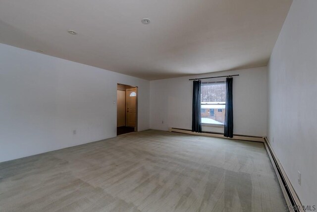 carpeted empty room featuring a baseboard radiator