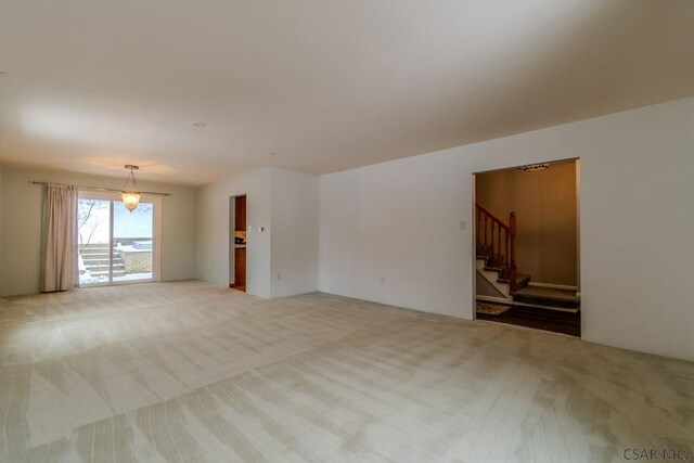 unfurnished living room featuring light colored carpet