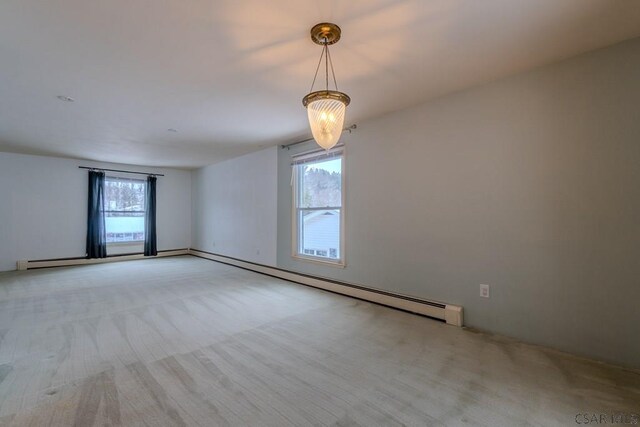 empty room with a wealth of natural light, light colored carpet, and baseboard heating