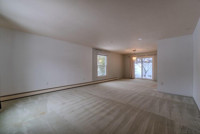 carpeted spare room with baseboard heating