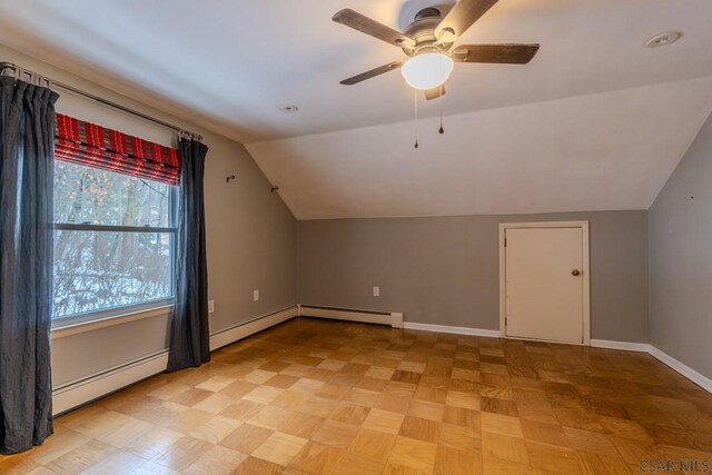 additional living space with ceiling fan, a baseboard radiator, lofted ceiling, and light parquet flooring