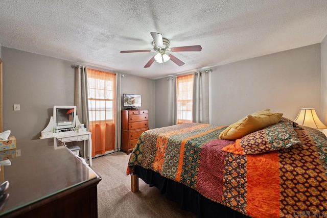 carpeted bedroom with ceiling fan and a textured ceiling