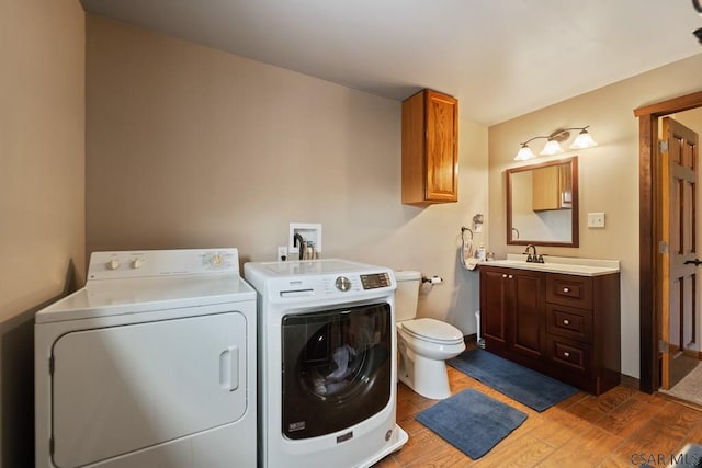 laundry area featuring sink, washer and clothes dryer, and dark hardwood / wood-style floors