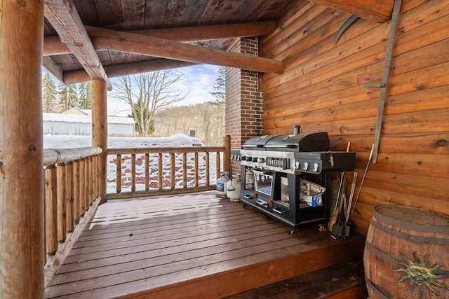 snow covered deck with a grill