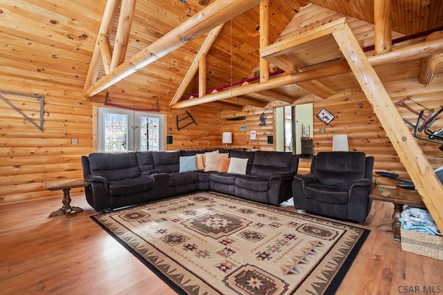 living room with wood-type flooring, rustic walls, high vaulted ceiling, and wooden ceiling