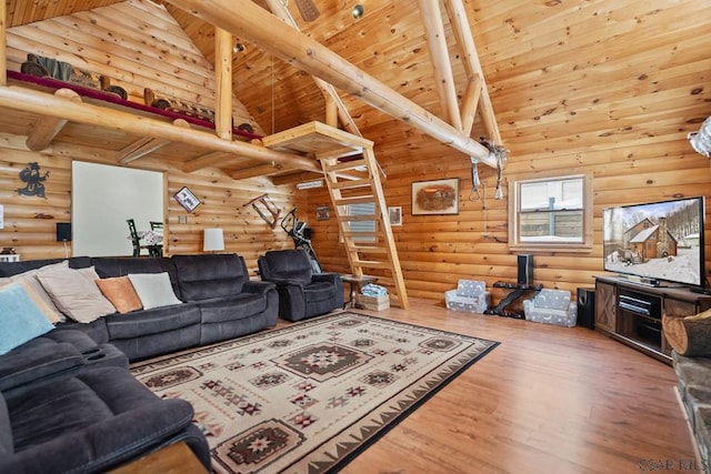 living room featuring beam ceiling, rustic walls, and high vaulted ceiling